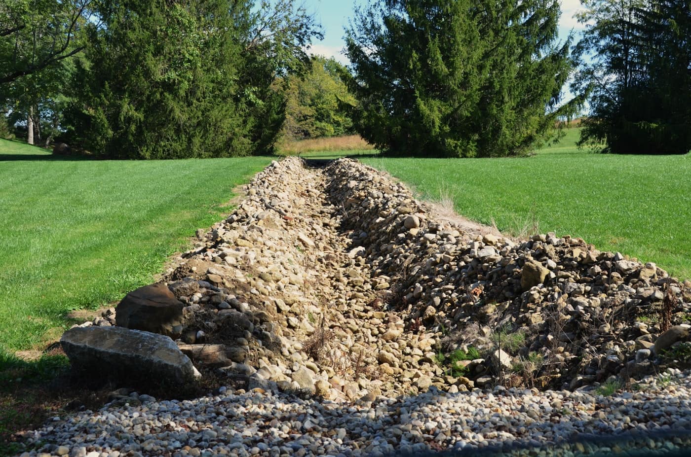 Drainage trench with gravel through a grassy Orlando yard
